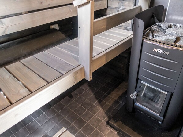 A sauna with wooden benches and a Harvia sauna heater.