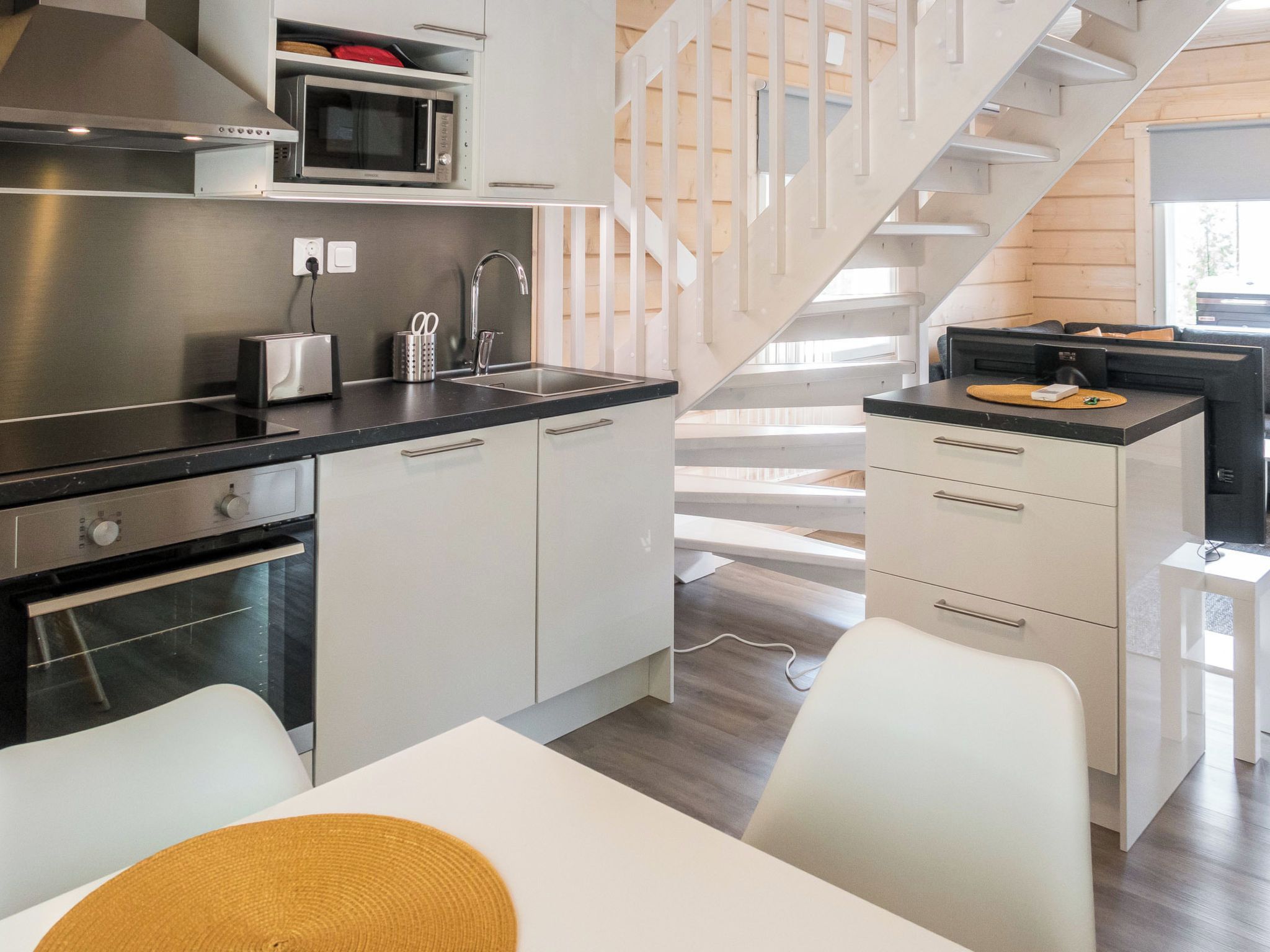 A modern kitchen with stainless steel appliances, a built-in microwave, and a white countertop.