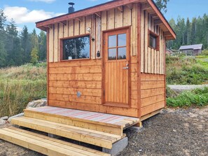 A small wooden cabin with a front door, windows, and a ramp leading to the entrance. - Kolin kangastus kanerva 4 by Interhome (Lieksa)