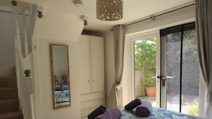 Una camera da letto con un letto, una cassettiera, uno specchio e una scala.