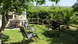 Un patio con mobili da esterno, un barbecue e vista sulla campagna.