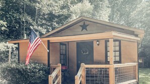 Un bâtiment en bois, surmonté d’une étoile, avec un drapeau américain et une pancarte indiquant « Bienvenue ».