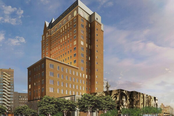 A multi-story hotel with a prominent corner design, large windows, and a brick facade. - Hotel Paso Del Norte Autograph Collection (El Paso)