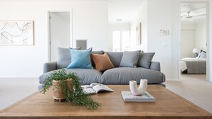 Un salon moderne avec un canapé gris, une table basse en bois et une plante en pot.