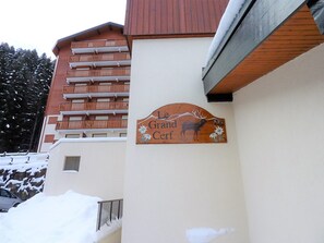 A building with a sign reading "Le Grand Cerf" and a balcony with wooden railings.