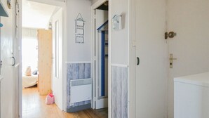 A hallway with wooden flooring, white walls, and a door leading to a bedroom. - 3-bedroom apartment with large balcony and garage near the casino (Saint-Jean-de-Monts)