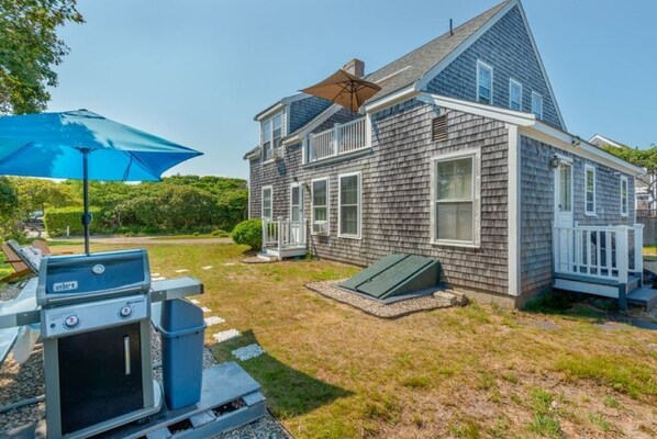 A two-story house with a sloped roof, a front porch, and a small attached garage.
