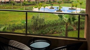 A balcony with a view of a swimming pool and greenery, and a row of buildings in the background. - PRESTIGIA GOLF CITY MARRAKECH (Marrakech)