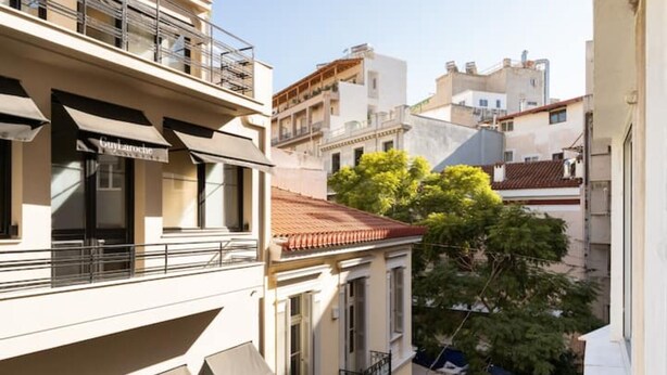 Um edifício de vários andares com varandas e toldos, provavelmente um imóvel residencial ou hotel.