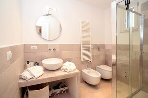 Een douche, een haardroger, een bidet, handdoeken