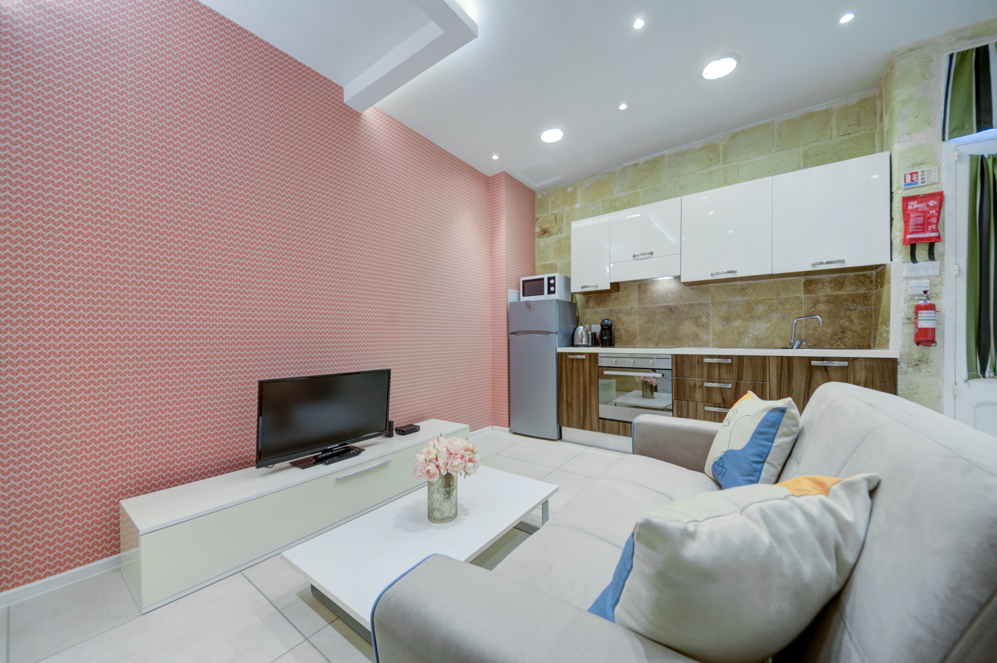 A modern living room with a flat-screen TV, a coffee table, and a sofa.