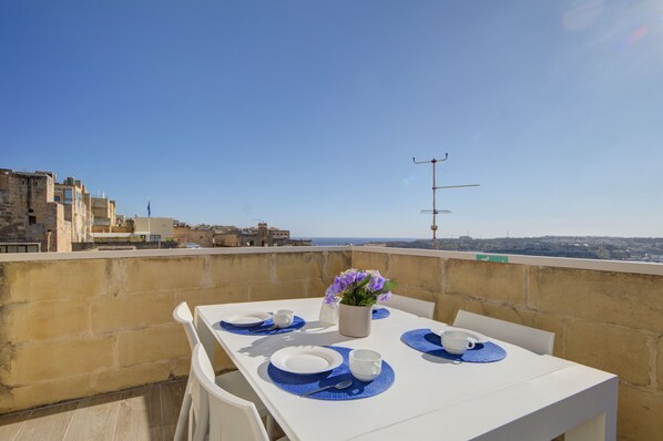 Una mesa para dos con vistas a la ciudad al fondo.