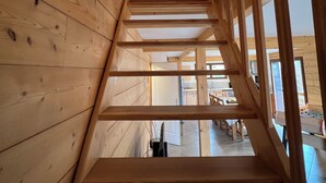 A wooden staircase leading to a room with a view of a kitchen and dining area. - Casa de Monzel - Jacuzzi and panoramic view of the Bresse mountains (La Bresse)