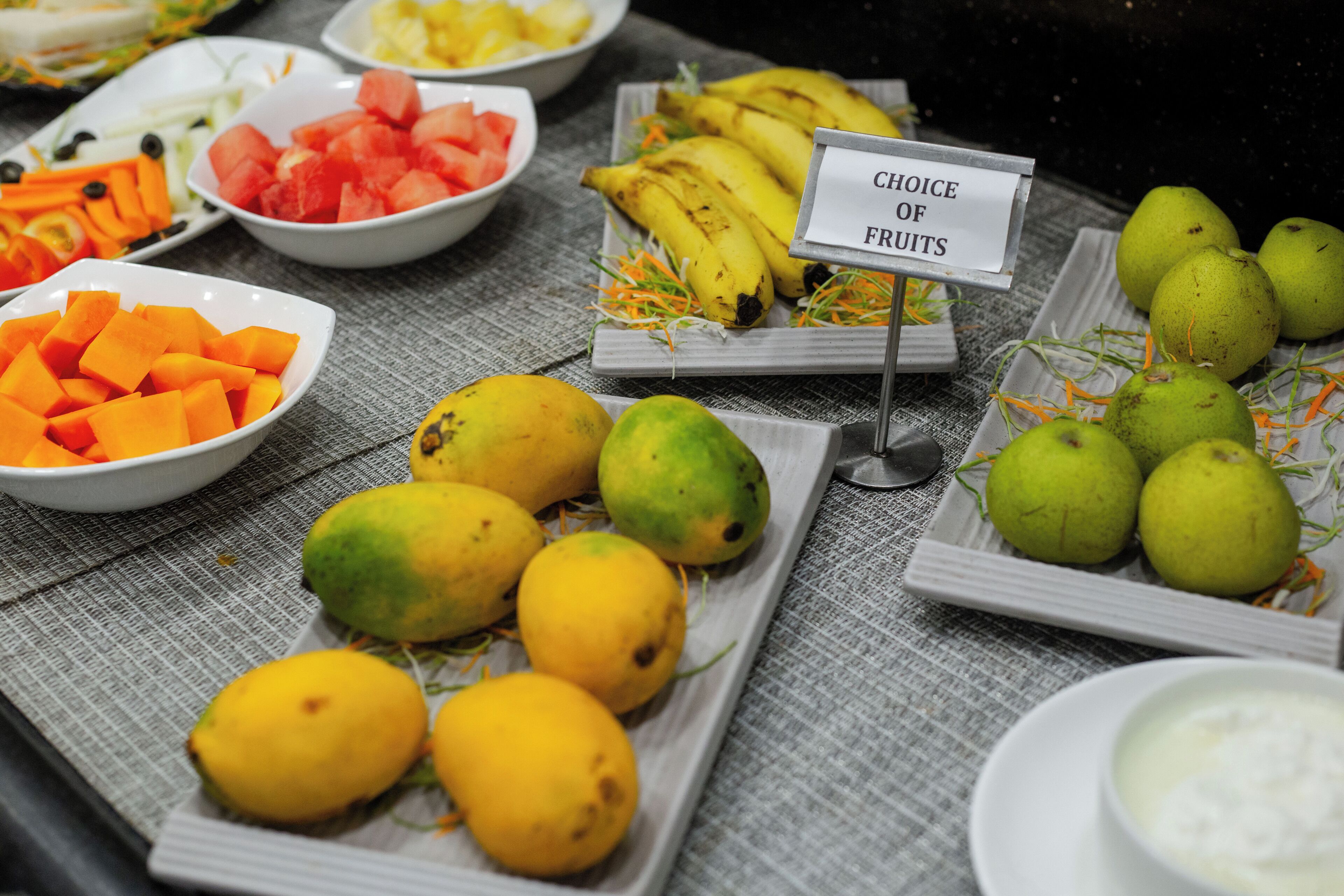 Una mesa de buffet con frutas y verduras variadas.