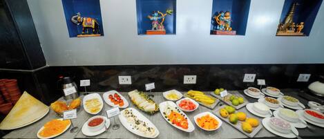 A buffet with various dishes and a wall with small figurines.