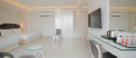 Habitación de hotel con cama, escritorio, silla, mesita y televisor.