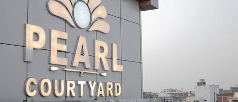 A building with a sign that reads "PEARL COURTYARD".