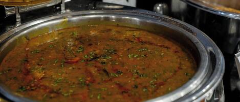 A large metal pot filled with a thick, textured soup or stew, likely served in a restaurant or buffet setting.