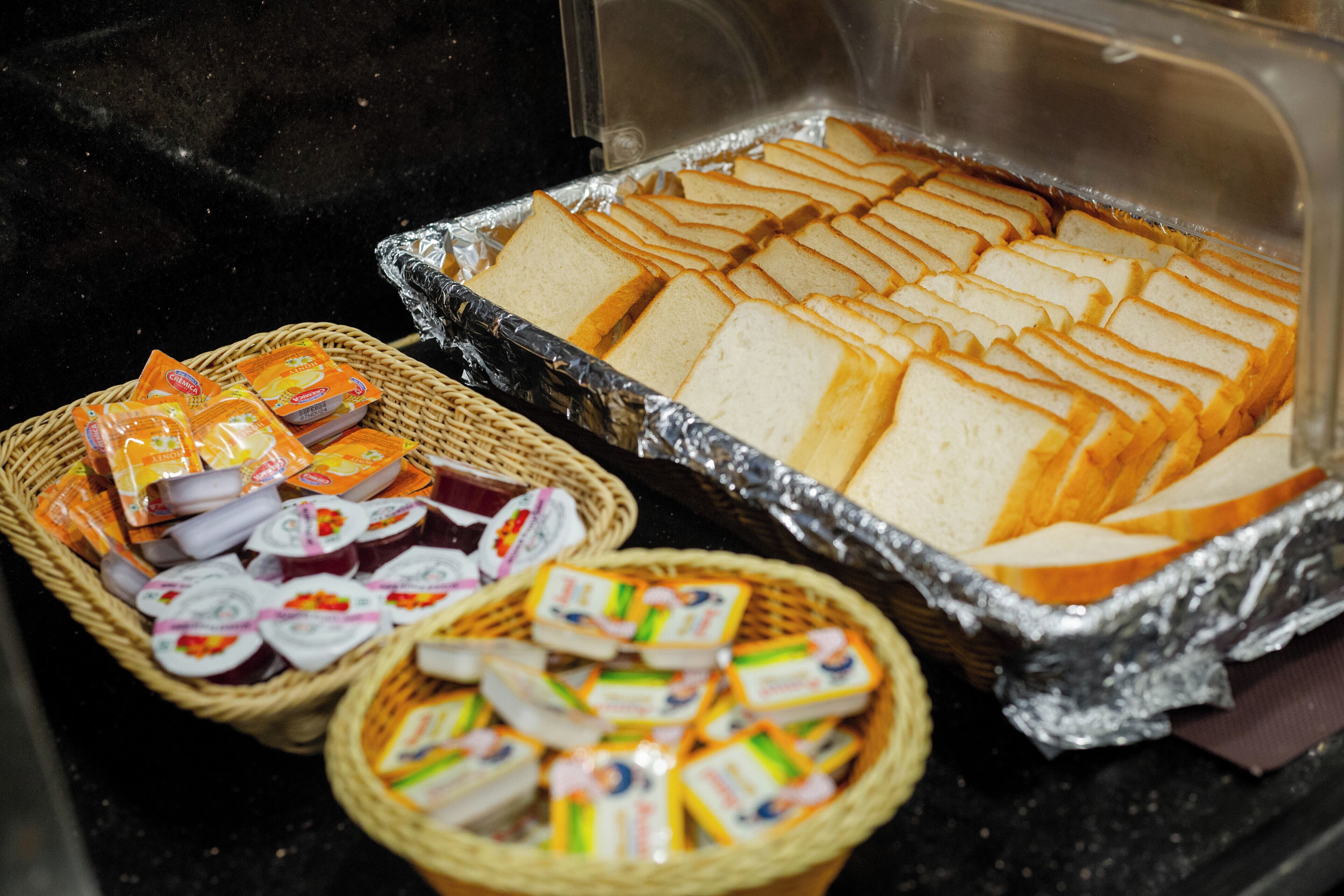 Un buffet proposant du pain tranché, divers produits alimentaires emballés et des condiments.