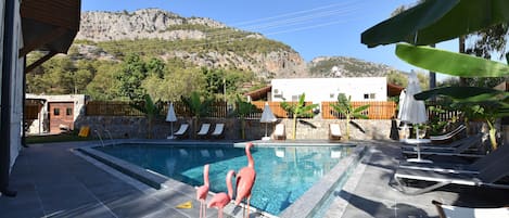 Piscine extérieure, parasols de plage, chaises longues