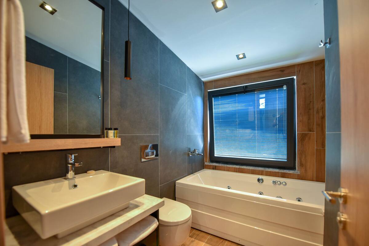 Habitación de lujo | Baño | Regadera, regadera tipo lluvia, amenidades de baño ecológicas