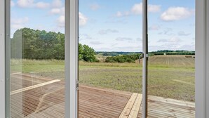 A view from a room with large windows overlooking a rural landscape with fields and trees. - 4 bedroom gorgeous home in Løgstrup (Løgstrup)