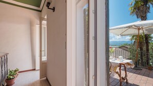A corridor with a door leading to a patio area with a table and chairs, potted plants, and a view of the sea. - Awesome home in Rieti with WiFi (Rieti)