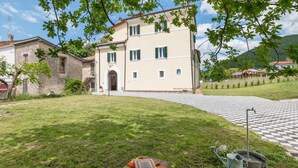 A villa with a checkered pathway leading to the entrance, surrounded by a grassy lawn and trees. - Awesome home in Rieti with WiFi (Rieti)