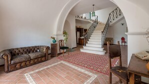 A spacious living area with a leather sofa, a patterned rug, and a staircase leading to an upper floor. - Awesome home in Rieti with WiFi (Rieti)
