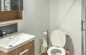A bathroom with a white sink, a toilet, and a mirror above the sink. - Beautiful apartment in Pradelles with WiFi (Pradelles)