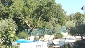 A pool area with lounge chairs and a covered section. - Vacation home near Rovinj quiet location with large garden, terrace, WLAN (Mrgani)