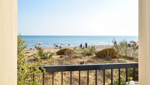 Une plage avec des gens, des parasols et un ciel dégagé.