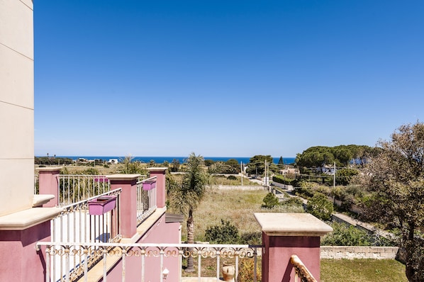 A balcony with a view of the sea and a clear sky.