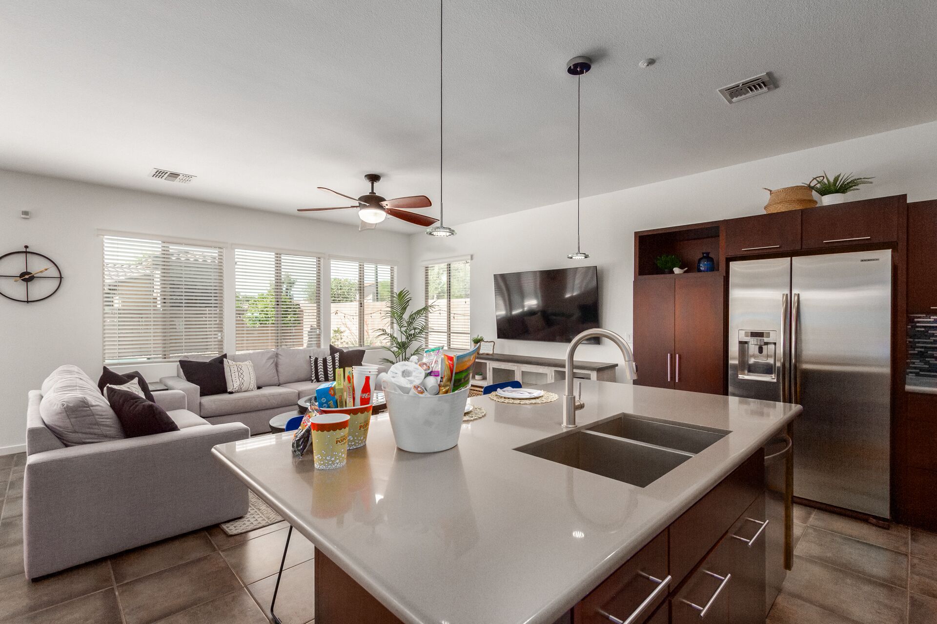A modern kitchen with a central island, stainless steel appliances, and a dining area with a sofa and coffee table.