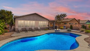 Piscina com lareira, espreguiçadeiras e área de estar com luzes de corda.