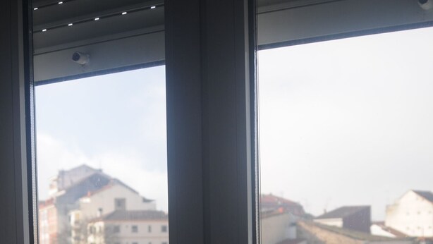 A window with a view of a bridge and buildings across a body of water. - Hotel Santa Clara (Monforte de Lemos)