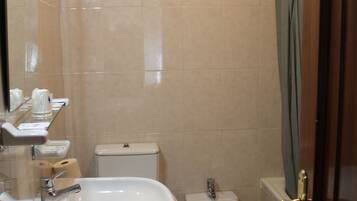 Un baño con lavabo, bidé, inodoro y espejo.