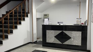 A reception area with a marble floor, a reception desk, and a staircase. - Hotel Santa Clara (Monforte de Lemos)