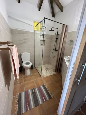 Ein Badezimmer mit Dusche, Toilette und Waschbecken.