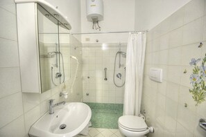 Ein Badezimmer mit Waschbecken, Toilette, Dusche und Spiegel.