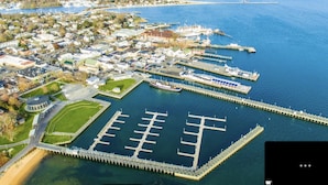 Vista aérea de un puerto deportivo con muelles y un pueblo cercano.