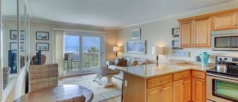 A kitchen with wooden cabinets, a granite countertop, and a large island.