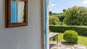 Ein Zimmer mit einer Holztür, die in einen Garten führt.