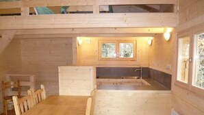 A wooden cabin with a dining area, a kitchenette, and a window. - Chalet, view mountain, terrace, tv, 85m², Villard de Lans (Lans-en-Vercors)