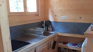 A compact kitchen with wooden cabinets, a built-in stove, and a small countertop. - Chalet, view mountain, terrace, tv, 85m², Villard de Lans (Lans-en-Vercors)
