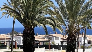 Un quartier résidentiel situé sur la côte, avec des palmiers et des maisons aux toits de tuiles.