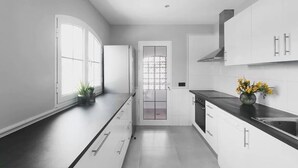 Une cuisine moderne avec des meubles blancs, un plan de travail noir et une fenêtre offrant une belle vue.