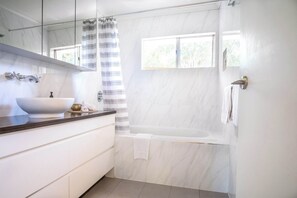 Bathtub, hair dryer, towels, shampoo