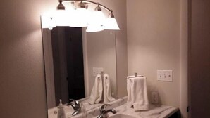A bathroom with a marble sink, a mirror, and a light fixture above the mirror. - Relax in the country at Countryside Villas! - Villa A (Jackson)