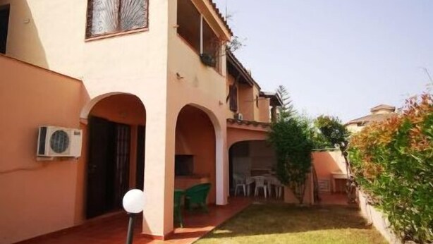 A two-story building with a flat roof, a covered patio area, and a small garden. - Sardinia Villasimius coastline, ins (Quartu Sant'Elena)